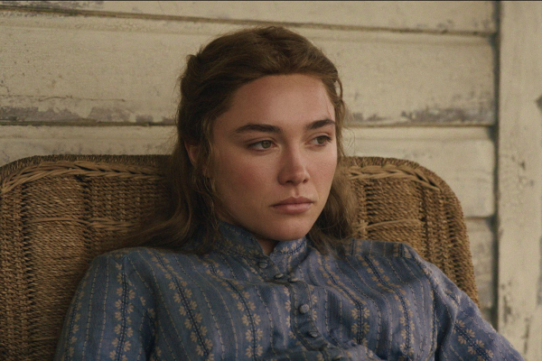 Florence Pugh as Cathy Ames in episode 103 of East of Eden sitting on the front porch in a wicker chair.